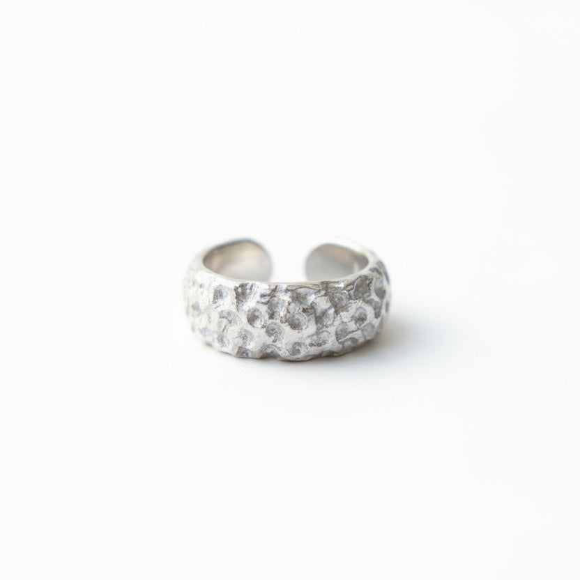 Silver ring with embedded stones on a white background