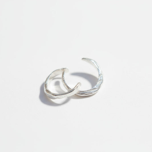 Silver ear cuff on a light gray background