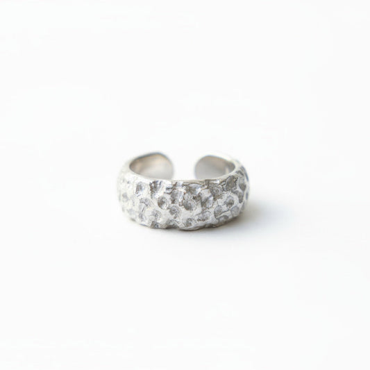Silver ring with embedded stones on a white background