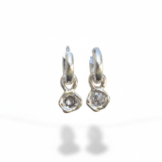 Pair of silver hoop earrings with clear gemstones on a white background