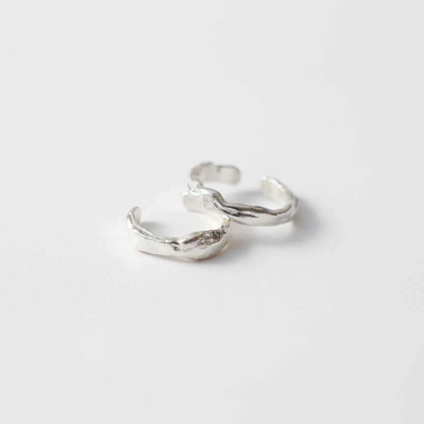 Pair of silver hoop earrings on a light gray background