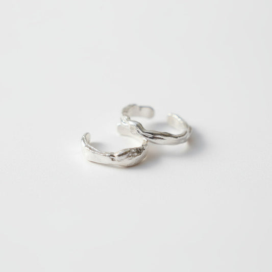 Pair of silver hoop earrings on a light gray background