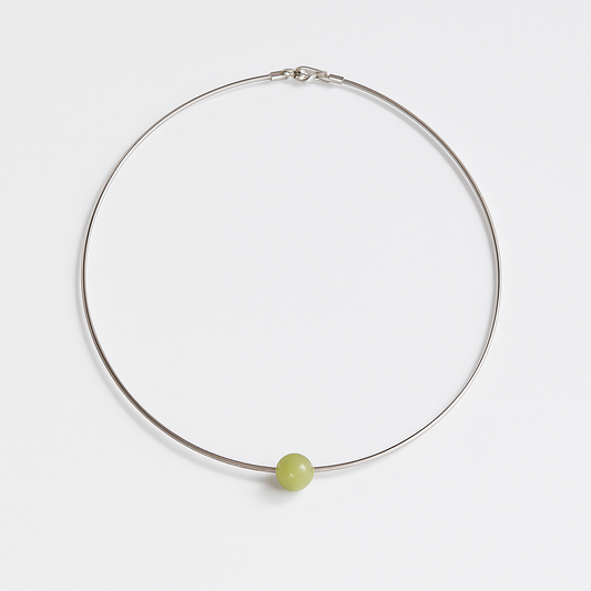 Necklace with a green bead on a white background